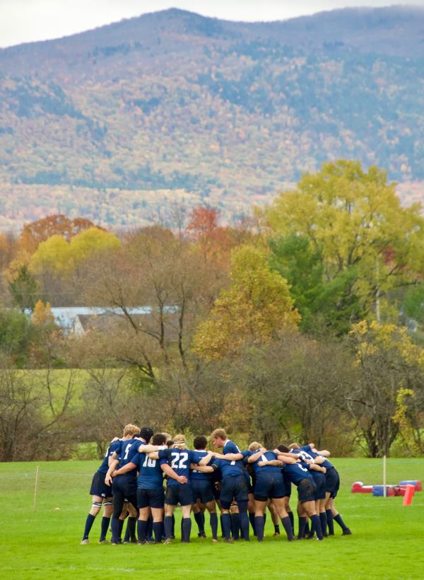 rugby huddle with mountain in back
